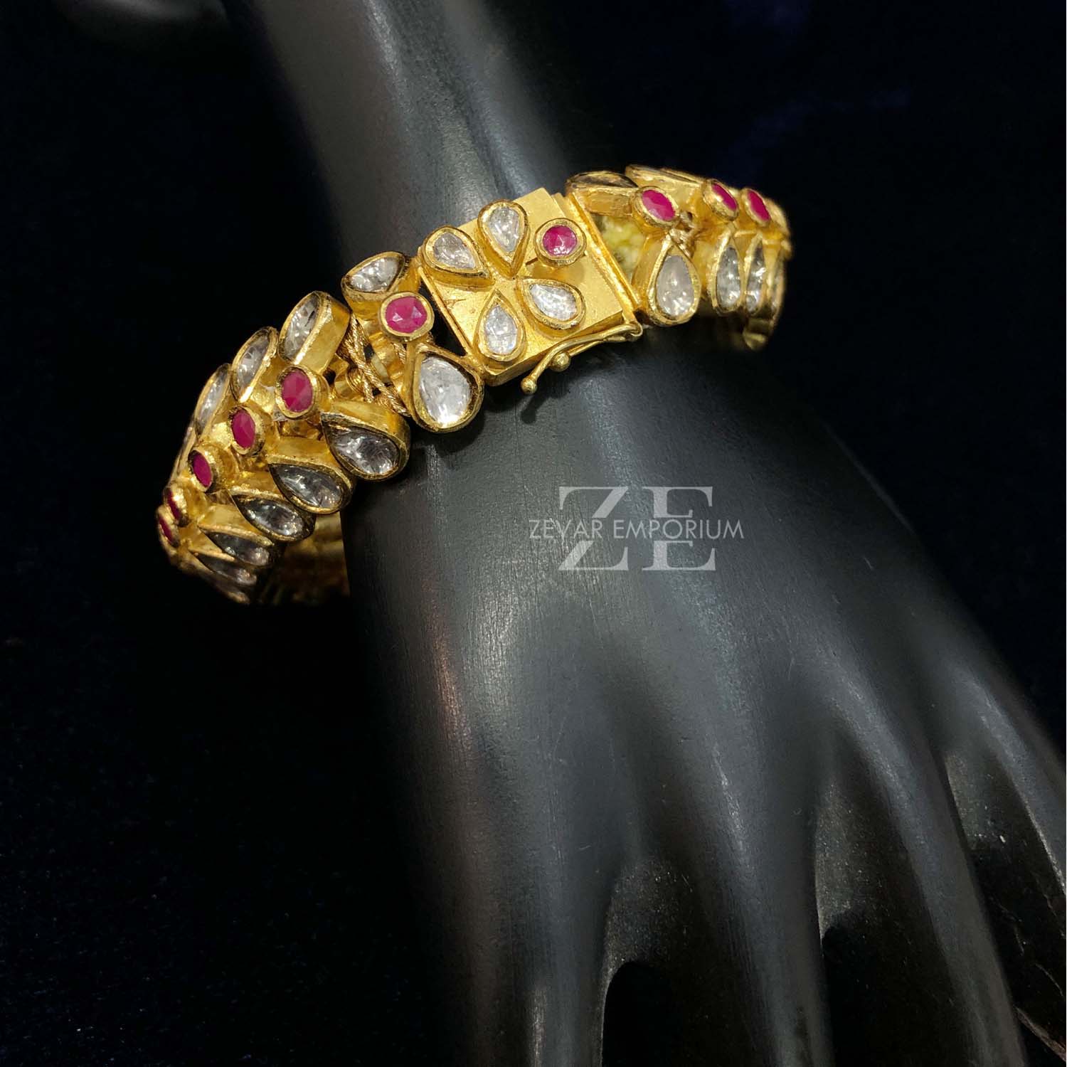 Macro shot of round rubies and Polki diamonds in 18k gold Jadau setting