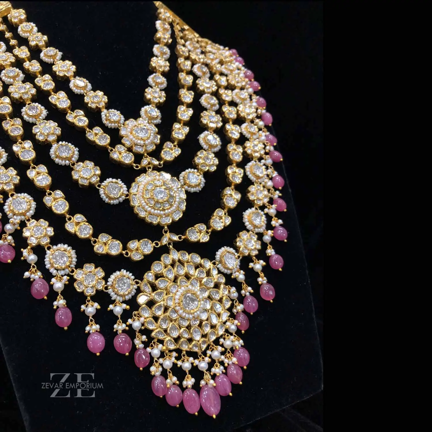 Luxurious five layered bridal raani haar necklace featuring intricate uncut diamond floral links and hanging pink beads.